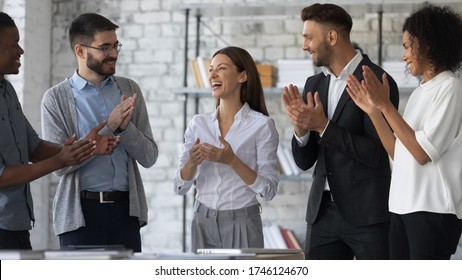 Friendly diverse employees congratulating businesswoman with business achievement, great work results or job promotion, business people applauding and cheering, standing in modern office - Shutterstock ID 1746124670
