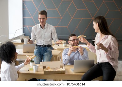 Friendly Diverse Team Talking And Laughing Eating Pizza Together, Happy Colleagues Sharing Meal, Multiracial Coworkers Group Enjoying Lunch At Break, Good Relations And Office Food Delivery Concept