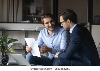 Friendly elder male employee mentor leader explaining paperwork to younger newbie colleague intern in modern office space, capable millennial lawyer assistant convincing customer in profits of deal - Shutterstock ID 1863565261