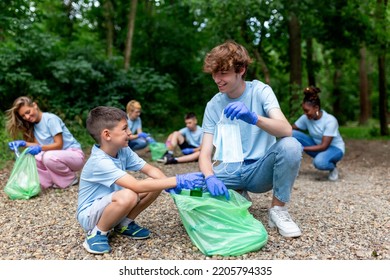 Friendly Family And Friends Organized A Cleaning Day To Clean The Park Of Household Garbage. People Participate In Natural Cleaning