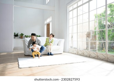 Friendly family playing with toddler in living room Copy space available wide angle - Shutterstock ID 2302827593