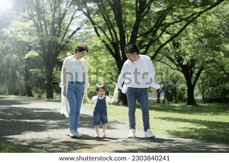 A friendly family taking a walk Image of a family holding hands in the fresh green