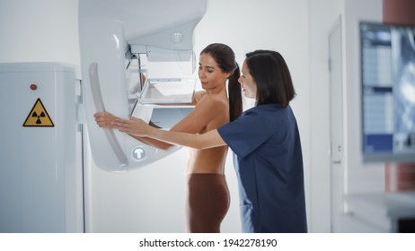 Friendly Female Doctor Explains the Mammogram Procedure to a Topless Adult Female Patient Undergoing Mammography Scan. Healthy Multiethnic Woman Does Cancer Prevention Routine in Hospital Room.