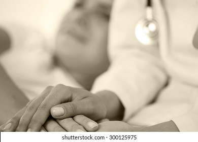 Friendly Female Doctor Hands Holding Patient Hand Lying In Bed For Encouragement, Empathy, Cheering And Support While Medical Examination. Bad News Lessening, Compassion, Trust And Ethics Concept