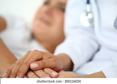 Friendly Female Doctor Hands Holding Patient Hand Lying In Bed For Encouragement, Empathy, Cheering And Support While Medical Examination. Bad News Lessening, Compassion, Trust And Ethics Concept