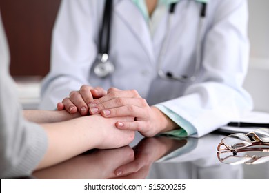 Friendly female doctor hands holding patient hand sitting at the desk for encouragement, empathy, cheering and support while medical examination. Bad news lessening, medicine and health care concept  - Powered by Shutterstock