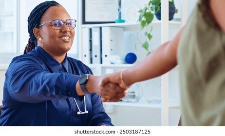 Friendly Female Doctor Shaking Hands with Patient in Medical Office, Establishing Trust and Professional Connection - Powered by Shutterstock