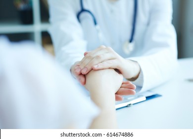 Friendly Female Doctor's Hands Holding Female Patient's Hand For Encouragement And Empathy. Partnership Trust And Medical Ethics Concept.