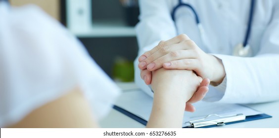 Friendly Female Doctor's Hands Holding Female Patient's Hand For Encouragement And Empathy. Partnership Trust And Medical Ethics Concept.