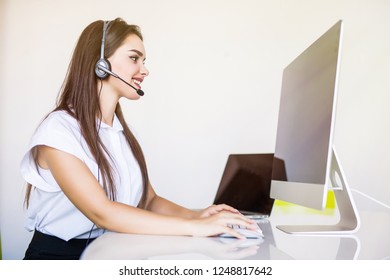 Friendly female helpline operator with headphones and computer call center