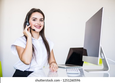 Friendly female helpline operator with headphones and computer call center
