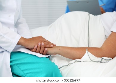 Friendly female medicine doctor hands holding pregnant woman's hand lying in bed for encouragement, empathy, cheering and support while medical examination. New life of abortion concept