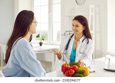 Friendly female nutritionist advises woman on diet plan and talk about benefits of raw vegetables. Doctor consults young female patient in hospital office. Concept of healthy eating and food science - Shutterstock ID 2190194177