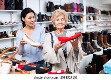 Friendly Female Sales Consultant Demonstrates Ballet Flats To A Mature Woman Customer Who Came To A Shoe Store For Shopping