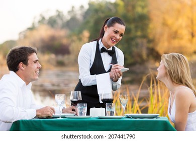 friendly female waitress taking order from cute young couple - Powered by Shutterstock