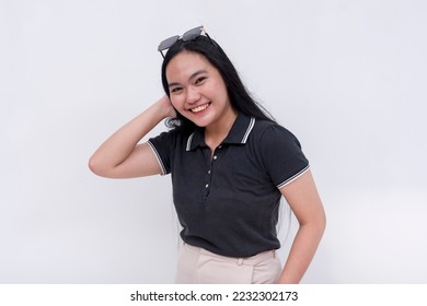 A friendly Filipino woman with strong long hair in her early 20s. Wearing a black polo shirt. Isolated on a white background. - Shutterstock ID 2232302173