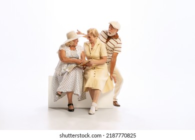 Friendly Gatherings. Handsome Senior Man And Two Charming Women In Vintage Retro Style Outfits Isolated On White Background. Concept Of Relations, Family, 1960s American Fashion Style And Art.