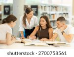 Friendly group of students prepare for classes and exams by studying together in the university library