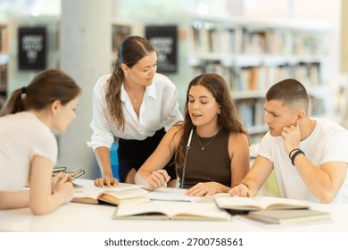Friendly group of students prepare for classes and exams by studying together in the university library - Powered by Shutterstock - Get 15% off with code: PIKWIZARD15