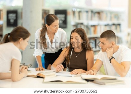 Friendly group of students prepare for classes and exams by studying together in the university library