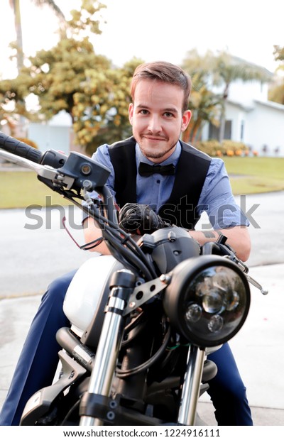 Friendly guy on a motorcycle smiling at the\
camera in the evening\
outdoor