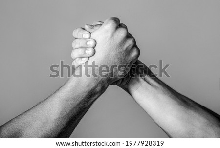Friendly handshake, friends greeting, teamwork, friendship. Handshake, arms, friendship. Hand rivalry vs challenge strength comparison Black and white