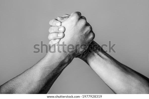 Friendly handshake, friends greeting, teamwork,\
friendship. Handshake, arms, friendship. Hand rivalry vs challenge\
strength comparison Black and\
white