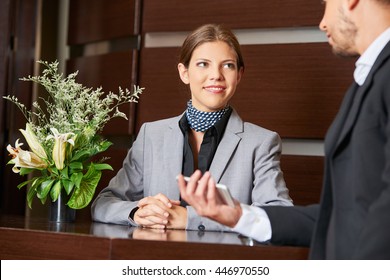 Friendly Hotel Receptionist And Business Guest At Check-in