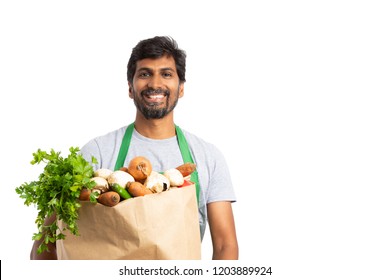 Friendly Indian Grocery Store Employee Holding Fresh Vegetable Bag As Healthy Concept With Smile Isolated On White