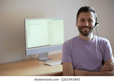 Friendly and knowledgeable customer service representative ready to assist with any inquiries. Man in front of computer is wearing headset, ready to answer customer calls. 