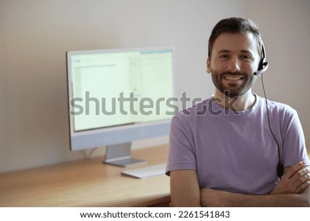 Friendly and knowledgeable customer service representative ready to assist with any inquiries. Man in front of computer is wearing headset, ready to answer customer calls. 