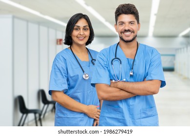 Friendly Latin American Male And Female Nurses At Vaccination Station Ready For Vacinating Patients Against Coronavirus Infection