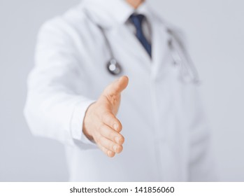 friendly male doctor with open hand ready for hugging - Powered by Shutterstock