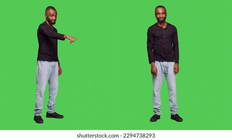 Friendly male model waving at someone on camera, saying hi or goodbye in studio. Young person smiling and greeting people with hello, standing over full body greenscreen backdrop. - Powered by Shutterstock