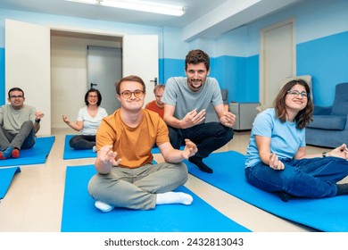 Friendly male yoga instructor directing a class with people with special needs and down syndrome - Powered by Shutterstock