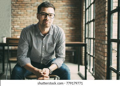 Friendly Man Sitting At Window In Loft Cafe