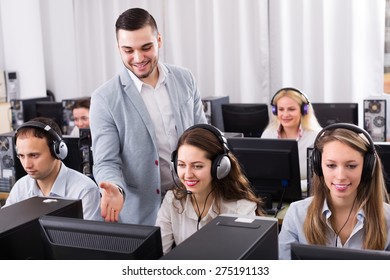 Friendly manager watching his business team working process  - Powered by Shutterstock