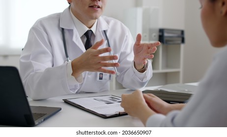 Friendly medic service people or asia male help talk discuss of medical exam record test result at clinic office desk. Young sad serious stress woman visit, follow , listen, see doctor at hospital.