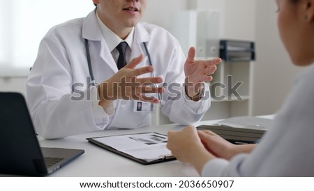 Friendly medic service people or asia male help talk discuss of medical exam record test result at clinic office desk. Young sad serious stress woman visit, follow , listen, see doctor at hospital. Stock photo © 