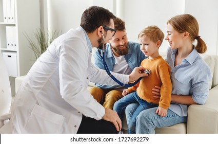 Friendly medical practitioner using stethoscope on chest of happy boy during family visit in cozy office in modern clinic
