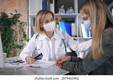 Friendly Middle Aged Female Doctor Encouraging, Supporting Patient After Medical Examination