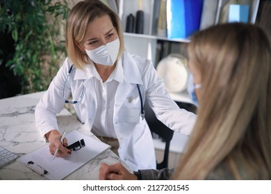 Friendly Middle Aged Female Doctor Encouraging, Supporting Patient After Medical Examination