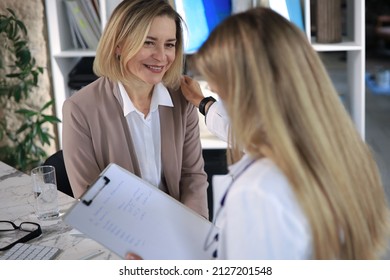 Friendly Middle Aged Female Doctor Encouraging, Supporting Patient After Medical Examination