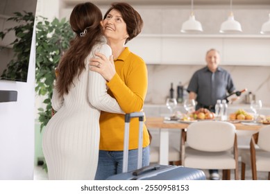 Friendly mother-in-law greeting visiting young daughter-in-law with tender kiss, embodying warm welcome in comfy home setting. Intergenerational family bonding concept.. - Powered by Shutterstock