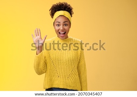 Friendly outgoing excited cute millennial female coworker newbie greeting team waving palm hi hello gesture energized get know new people welcoming greeting friends, standing yellow background