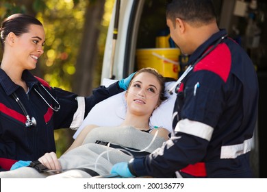 friendly paramedics talking to patient on stretcher