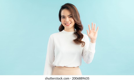 Friendly, Pleasant And Cheerful East-asian Woman Raising Palm, Wave Hand Greeting, Saying Hi Or Hello And Smiling With Joyful Expression As Welcoming Newbies