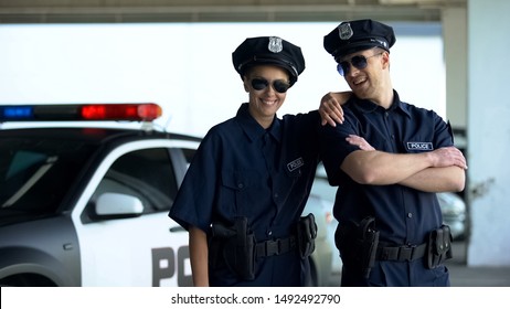 Friendly Police Officers In Uniform And Glasses Smiling To Camera, Law And Order