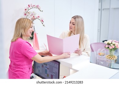 Friendly receptionist communicating with young female client - Powered by Shutterstock