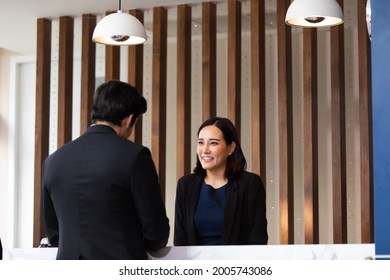 Friendly Receptionist Woman Working At Desk In Hotel Lobby. Leisure And Travel At Holidays.